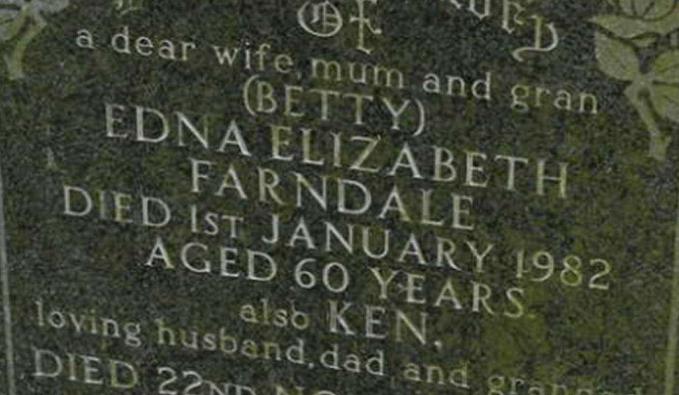 A tombstone in a cemetery
Description automatically generated